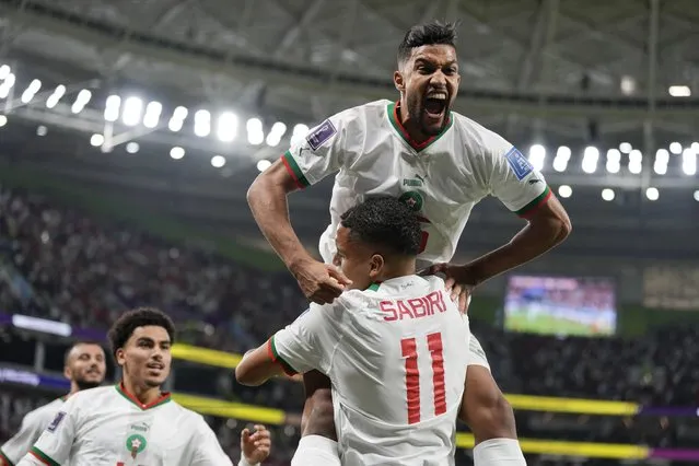 Morocco's Yahya Jabrane, top, celebrates with Abdelhamid Sabiri (11) after Sabiri scored a goal during the World Cup group F soccer match between Belgium and Morocco, at the Al Thumama Stadium in Doha, Qatar, Sunday, November 27, 2022. (Photo by Frank Augstein/AP Photo)