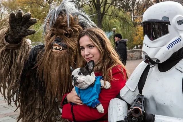A woman and her dog pose for a picture with representatives of the Internet Party of Ukraine dressed as characters from Star Wars, including parliamentary candidate Stepan Mikhailovich Chewbacca (L), on October 24, 2014 in Kiev, Ukraine. The country's parliamentary elections, scheduled for Sunday, are seen as key to President Petro Poroshenko's ability to advance his agenda, stabilize the economy, and end fighting in the country's east. (Photo by Brendan Hoffman/Getty Images)