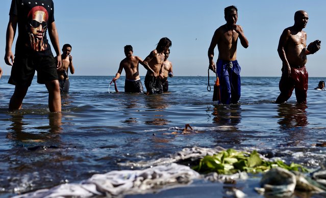 Filipino penitents bath in Manila Bay after performing self-flagellation during Good Friday celebration in Rosario, Philippines, 18 April 2025. Catholics in the Philippines hold various religious practices in observance of the Holy Week of Lent, from Palm Sunday to Easter Sunday. (Photo by Francis R. Malasig/EPA/EFE)