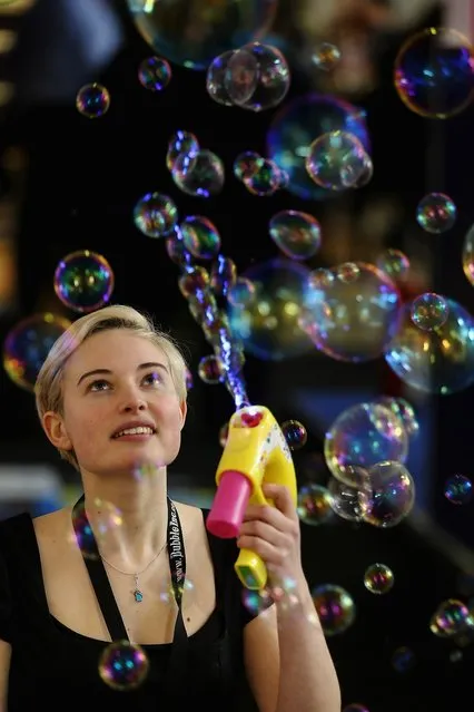 A woman on a trade stand blows bubbles during the 2013 London Toy Fair at Olympia Exhibition Centre on January 22, 2013 in London, England. The annual fair which is organised by the British Toy and Hobby Association, brings together toy manufacturers and retailers from around the world.  (Photo by Dan Kitwood)