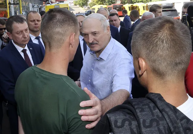 Belarusian President Alexander Lukashenko, center, speaks to an employee of the Minsk Wheel Tractor Plant in Minsk, Belarus, Monday, August 17, 2020. Workers heckled President Alexander Lukashenko as he visited a factory and strikes grew across Belarus, raising the pressure on the authoritarian leader to step down after 26 years in office. (Photo by Nikolai Petrov/BelTA Pool Photo via AP Photo)