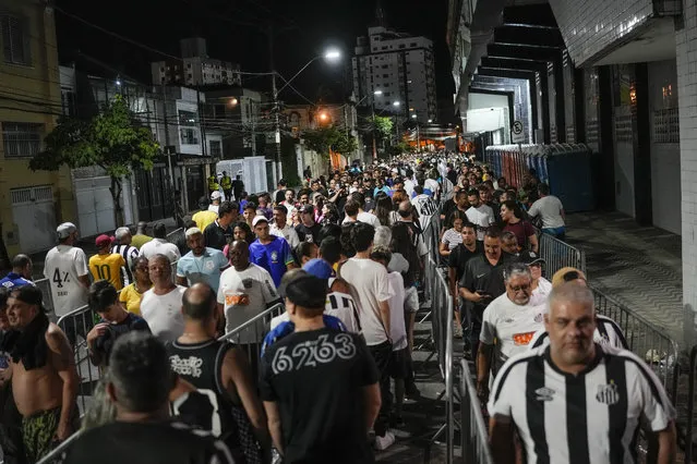 Soccer fans line up to attend the funeral procession of late Brazilian soccer legend Pele at Vila Belmiro stadium where his wake was held in Santos, Brazil, early Tuesday, January 3, 2023. (Photo by Matias Delacroix/AP Photo)