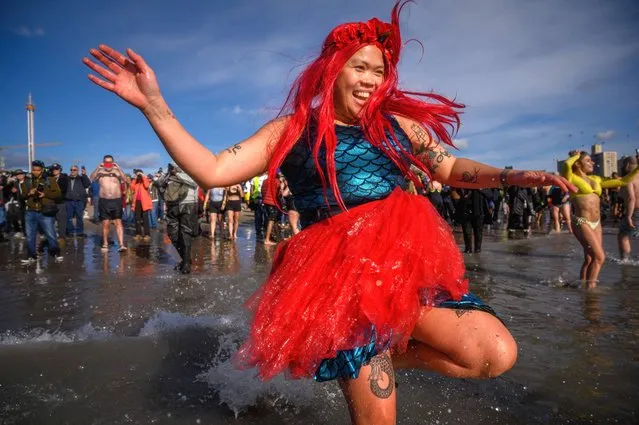 A swimmer enters the water during the annual New Year's day “Polar Bear Plunge” at Coney Island beach, New York, on January 1, 2023. (Photo by Ed Jones/AFP Photo)