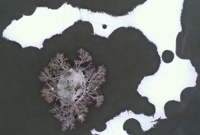 An aerial view shows a frozen lake, with areas covered in snow in Richmond Park, south west London on December 12, 2022. (Photo by Daniel Leal/AFP Photo)