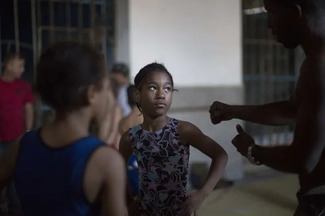 A wrestling teacher gives instructions to a child during a lesson in downtown Havana, November 11, 2014. (Photo by Alexandre Meneghini/Reuters)