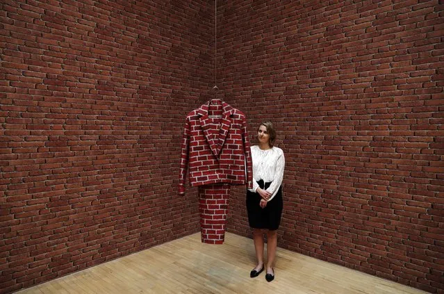 A gallery employee poses with an installation entitled “Brick Suit” by artist Anthea Hamilton, during a photocall for the 2016 Turner Prize, at Tate Britain in London on September 26, 2016. Artists Michael Dean, Anthea Hamilton, Helen Marten and Josephine Pryde are the four artists shortlisted for the 2016 Turner Prize. The winner will be announced December 5, 2016. (Photo by Adrian Dennis/AFP Photo)