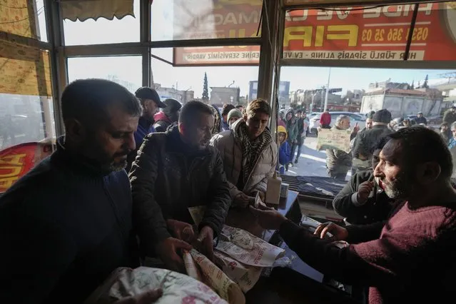 People line up in a bakery to buy bread due the shortage of food in Kahramanmaras, southern Turkey, Tuesday, February 7, 2023. (Photo by Khalil Hamra/AP Photo)
