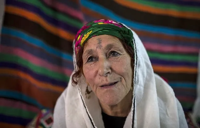 Fatma Benyadir, 75, a berber woman from the Chaouia region, who has facial tattoos, sits inside her house in Chalma at the Aures Mountain near the eastern city of Batna, Algeria October 9, 2015. A local woman tattooed Benyadir when she was 12 years old. "I did it without telling my parents. All the girls my age were tattooed", Benyadir said. (Photo by Zohra Bensemra/Reuters)