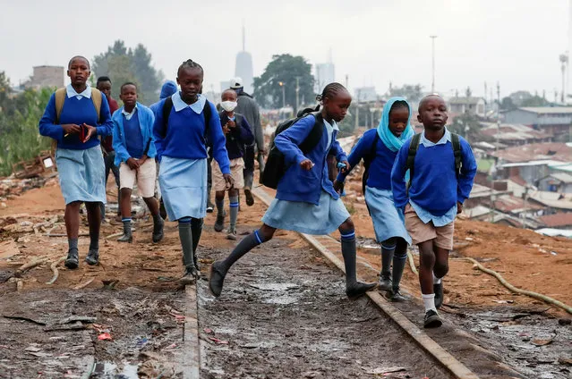 School children walk along the Kenya-Uganda railway line during the partial reopening of schools, after the government scrapped plans to cancel the academic year due to the coronavirus disease (COVID-19) pandemic, in Kibera slums of Nairobi, Kenya on October 12, 2020. (Photo by homas Mukoya/Reuters)