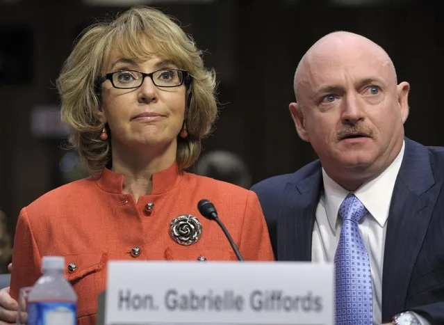 Former Arizona Rep. Gabrielle Giffords, who was seriously injured in the mass shooting that killed six people in Tucson, Ariz. two years ago, sits with her husband Mark Kelly, on Capitol Hill in Washington, Wednesday, January 30, 2013, and gives an opening statement before the Senate Judiciary Committee hearing on gun violence. Supporters and opponents of stricter gun control measures face off at a hearing on what lawmakers should do to curb gun violence in the wake of last month's shooting rampage in Newtown, Ct., that killed 20 schoolchildren. (Photo by Susan Walsh/AP Photo)