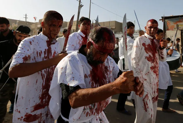Iraq Shi'ite Muslim men bleed as they gash their foreheads with swords and beat themselves while commemorating Ashura in Baghdad, Iraq ,October 12, 2016. (Photo by Ahmed Saad/Reuters)