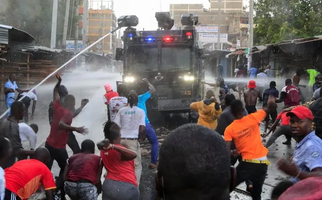 Riot police use water cannons as they clash with supporters of Kenya's opposition leader Raila Odinga of the Azimio La Umoja (Declaration of Unity) One Kenya Alliance, as they participate in a nationwide protest over cost of living and President William Ruto's government in Eastleigh neighbourhood of Nairobi, Kenya on March 20, 2023. (Photo by Thomas Mukoya/Reuters)