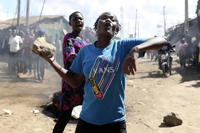 A protestor holds stone to throw at riot police on the outskirts of Nairobi, Thursday, March 30, 2023. (Photo by Brian Inganga/AP Photo)