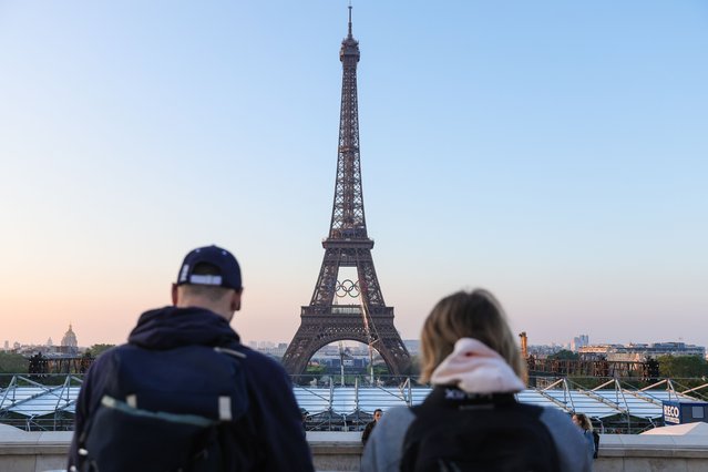 People watch the Olympic rings' installation on the Eiffel Tower 50 days before the Paris 2024 Olympic and Paralympic Games in Paris, France, 07 June 2024. Summer Olympics will be held in Paris, France, from 26 July to 11 August 2024. (Photo by Teresa Suarez/EPA/EFE)