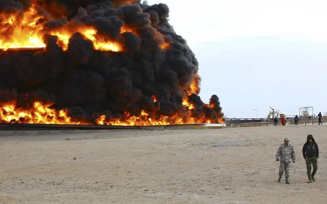 Firefighters try to put out the fire in an oil tank in Es Sider port December 26, 2014. A fire at an oil storage tank at Libya's Es Sider port has spread to two more tanks after a rocket hit the country's biggest terminal during clashes between forces allied to competing governments, officials said on Friday. (Photo by Reuters/Stringer)