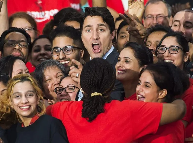 Canada's Prime Minister Justin Trudeau is swarmed by employees at the new Amazon fulfillment center, in Brampton, Ontario, Canada, Thursday, October 20, 2016. Trudeau says the high-tech facility will create more than 700 full-time jobs. (Photo by Nathan Denette/The Canadian Press via AP Photo)