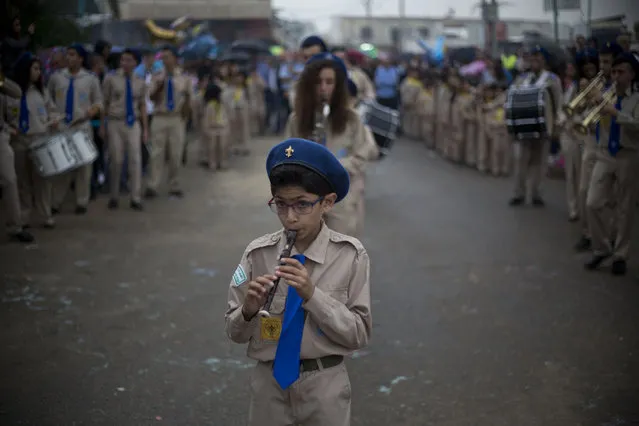 An Arab boy scout plays music during a procession parade to St. George church during a feast to commemorates the bringing of the remains of the great martyr St. George to Lod, Israel, Monday, November 16, 2015. Jerusalem’s Greek Patriarch believes the church contains the tomb of  St. George. (Photo by Ariel Schalit/AP Photo)