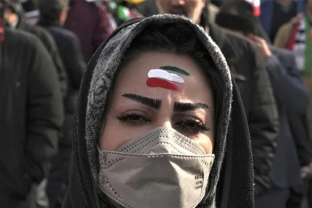 A woman with forehead painted with the Iranian flag's colors takes part in the annual rally commemorating Iran's 1979 Islamic Revolution, in Tehran, Iran, Saturday, February 11, 2023. Iran on Saturday celebrated the 44th anniversary of the 1979 Islamic Revolution amid nationwide anti-government protests and heightened tensions with the West. (Photo by Vahid Salemi/AP Photo)