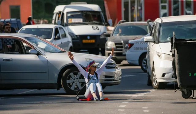 An Armenian opposition supporter sits on the ground as she blocks a road, after protest movement leader Nikol Pashinyan announced a nationwide campaign of civil disobedience in Yerevan, May 2, 2018. (Photo by Gleb Garanich/Reuters)