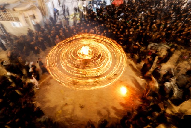 Shi'ite Muslims gather ahead of Ashura, the holiest day on the Shi'ite Muslim calendar, in Najaf, Iraq on July 3, 2025. Large torches known as masha'al are lit each night during the first ten days of Muharram as part of traditional Shi'ite mourning rituals. (Photo by Alaa al-Marjani/Reuters)