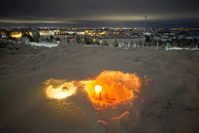 A candle burns on Saturday January 2, 2021, for the victims of the massive landslide that hit the residential area in Ask in Gjerdrum, Norway on Wednesday. The landslide cut across a road through Ask, home to some 5,000 people, leaving a deep, crater-like ravine that cars could not pass. (Photo by Haakon Mosvold Larsen/NTB via AP Photo)