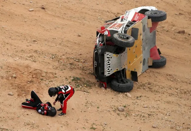 Toyota Gazoo Racing's Henk Lategan and Co-Driver Brett Cummings react after crashing during the 5th stage of the 2021 Dakar Rally held between the city of Riyadh and Al Qaisumah in Saudi Arabia on January 7, 2021. The navigator was assisted by the medical team via helicopter. (Photo by Hamad I Mohammed/Reuters)