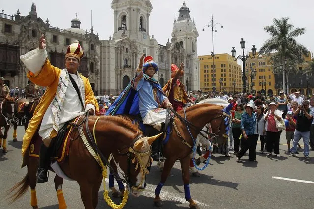 Policemen dressed as the Three Wise Men, Melchior, Balthasar and Gaspar, ride horses as they greet people during the celebration of Epiphany, or Three Kings' Day, in central Lima January 6, 2015. (Photo by Enrique Castro-Mendivil/Reuters)