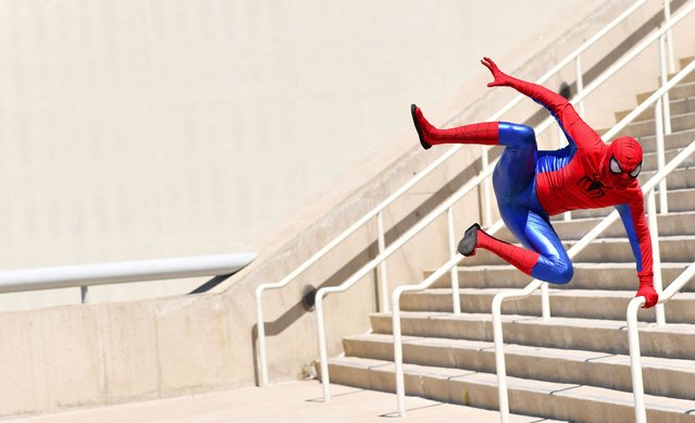 A Spiderman cosplayer jumps outside the convention center during Comic Con International in San Diego, California, July 28, 2024. (Photo by Chris Delmas/AFP Photo)