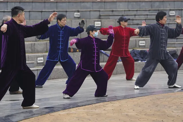 Residents practice Taiji at a park in Wuhan in central China's Hubei Province on Saturday, January 23, 2021. A year after it was locked down to contain the spread of coronavirus, the central Chinese city of Wuhan has largely returned to normal, even as China continues to battle outbreaks elsewhere in the country. (Photo by Ng Han Guan/AP Photo)