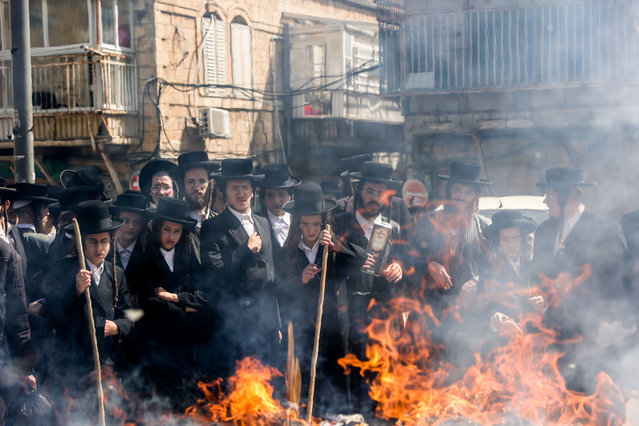 Ultra-Orthodox Jews pray and burn leavened bread at Mea Shearim neighborhood in Jerusalem, 05 April 2023. The burning of all products containing leavening agents, or Chametz, is a customary preparation ahead of the week-long Jewish high holiday of Passover that commemorates the Jewish exodus from Egypt in Biblical times. (Photo by Abir Sultan/EPA/EFE/Rex Features/Shutterstock)