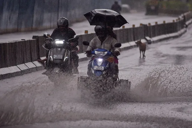 Motorcyclists drive along a partially waterlogged road, during a rain spell, in Chennai, India, 01 May 2023. The Indian Meteorological Department (IMD) on 30 April 2023, issued a yellow alert in 17 districts of the Tamil Nadu state for the next 48 hours due to a cyclonic circulation over the South East Arabian Sea and wind discontinuity over the North interior of the Tamil Nadu state. (Photo by Idrees Mohammed/EPA)