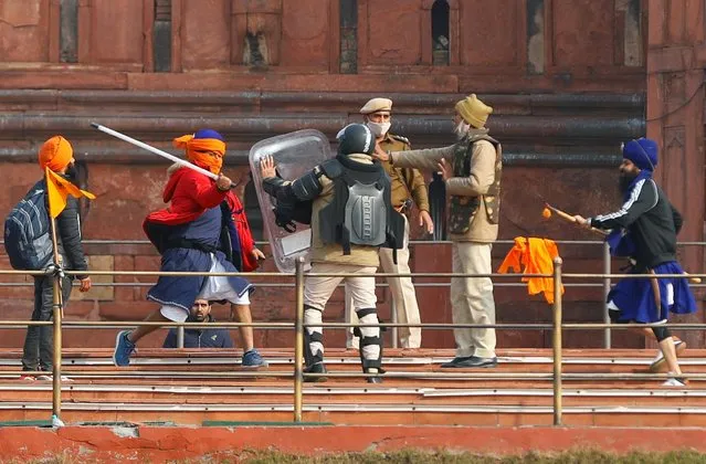 A Nihang (sikh warrior) beats a policeman with a baton during a protest against farm laws introduced by the government, at the historic Red Fort in Delhi, India, January 26, 2021. (Photo by Adnan Abidi/Reuters)