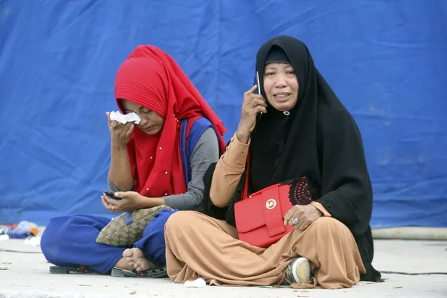 Relatives weep at Tigaras port after learning that their family members are among the passengers of a ferry which sank on Monday, in Lake Toba, North Sumatra, Indonesia Wednesday, June, 20, 2018. Distraught relatives slammed Indonesia's government for not enforcing basic safety measures on passenger boats and pleaded Wednesday for a bigger search effort for the people missing since a ferry sank on a picturesque Sumatran lake early this week. (Photo by Binsar Bakkara/AP Photo)
