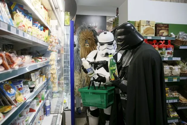 Darth Mykolaiovych Vader (R), who is dressed as the Star Wars character Darth Vader, and people dressed as Star Wars characters Chewbacca (L) and a Stormtrooper pose for a picture as they select products in a grocery store in Odessa, Ukraine, December 3, 2015. (Photo by Valentyn Ogirenko/Reuters)