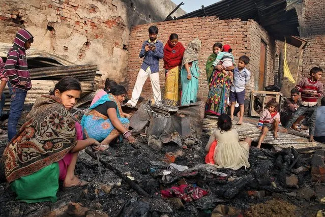 People are pictured amongst the rubble of their home after a fire in a slum area left hundreds homeless in the old quarters of Delhi, India, November 8, 2016. (Photo by Cathal McNaughton/Reuters)