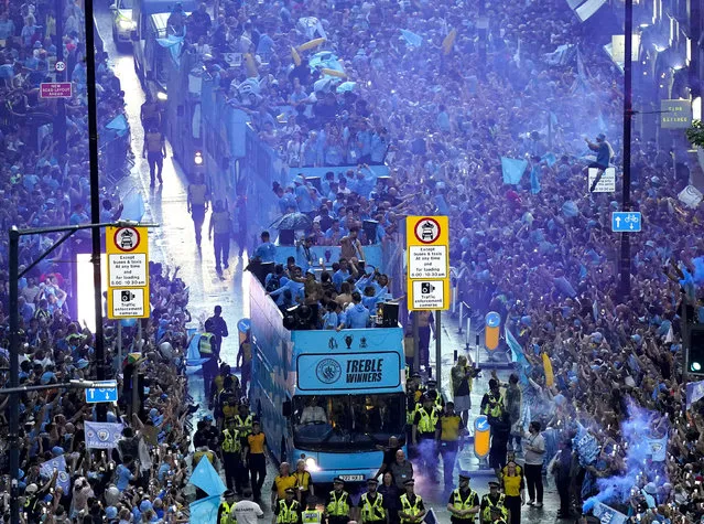 Manchester City's team ride during the parade to celebrate winning the Premier League, FA Cup and Champions League in Manchester, England, Monday June 12, 2023. (Photo by Danny Lawson/PA Wire via AP Photo)