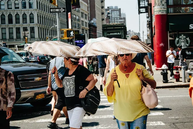 Two women with identical umbrellas walk under the sun in New York, New York, USA, 02 July 2018. Temperatures in New York City are expected to reach highs of 96 degrees fahrenheit (35.5 Celsius) as the east coast of US is experiencing a heat wave. (Photo by Alba Vigaray/EPA/EFE)