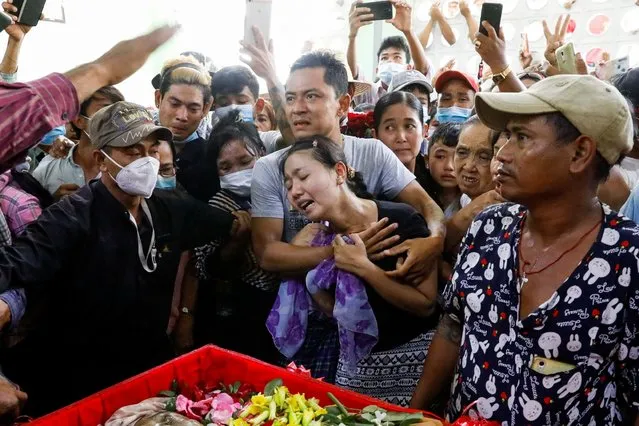 Family members attend the funeral of Zaw Myat Linn in Yangon, Myanmar, March 11, 2021. The official from deposed leader Aung San Suu Kyi's National League for Democracy (NLD) died in custody after being arrested early on Tuesday. Mourners wept over the open coffin, which showed his badly disfigured face. (Photo by Reuters/Stringer)