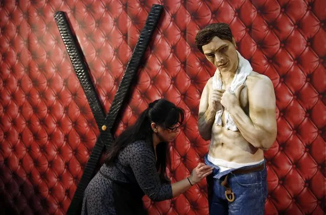 Cake maker Rosie Dummer puts the finishing touches to a life size cake model of Christian Grey from the book “Fifty-shades of Grey” as part of a display entitled “Fifty shades of cake”, on the opening day of the Cake International show in Manchester, northern England, February 6, 2015. (Photo by Phil Noble/Reuters)