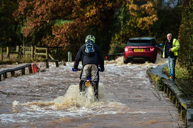 A biker ventures through deep flood water on Station Road, Broadclyst, Devon, where rivers burst their banks on November 21, 2016. (Photo by Ben Birchall/PA Wire)