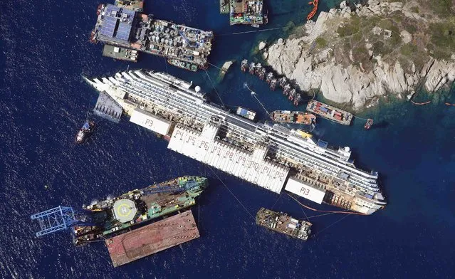 An aerial view shows the Costa Concordia as it lies on its side next to Giglio Island taken from an Italian navy helicopter in this August 26, 2013 file photo. (Photo by Alessandro Bianchi/Reuters)