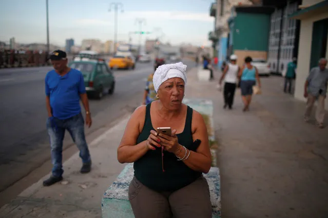 A woman checks her phone at the Malecon in Havana, Cuba on August 4, 2018. (Photo by Tomas Bravo/Reuters)