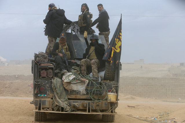 Members of the Iraqi Special Operations Forces (ISOF) ride in military vehicle during a battle with Islamic State militants in Mosul, Iraq, November 30, 2016. (Photo by Alaa Al-Marjani/Reuters)