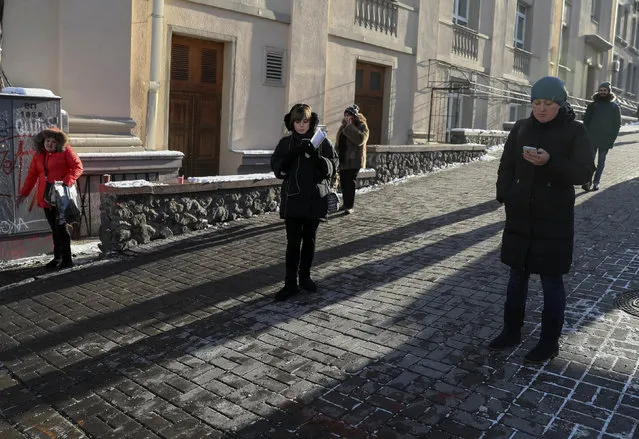 People use their mobile devices as they stand in the street in central Kiev, Ukraine, November 30, 2016. (Photo by Gleb Garanich/Reuters)