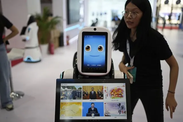 A robot receptionist with a screen showing Chinese President Xi Jinping is displayed at the annual World Robot Conference at the Beijing Etrong International Exhibition and Convention Center, Wednesday, August 16, 2023. (Photo by Ng Han Guan/AP Photo)