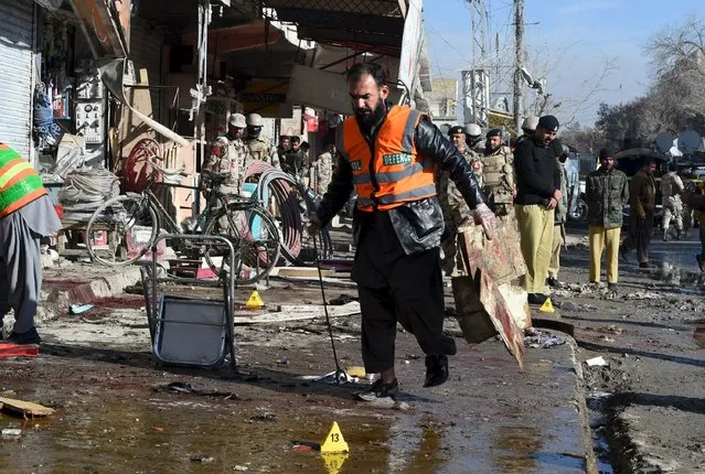 A rescue worker collects evidence from the site of a suicide bomb attack close to a polio eradication centre in Quetta, Pakistan, January 13, 2016. (Photo by Reuters/Stringer)