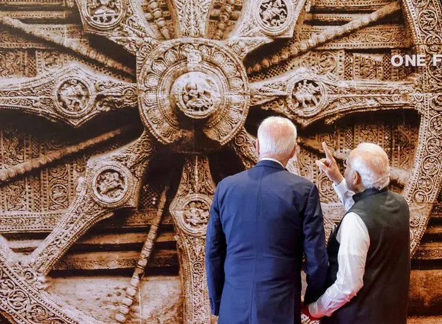 India's Prime Minister Narendra Modi (R) shows a mural of Konark Sun temple wheel from Indian state of Orissa to US President Joe Biden ahead of the G20 Leaders' Summit in New Delhi on September 9, 2023. (Photo by Ludovic Marin/Pool via  AFP Photo)