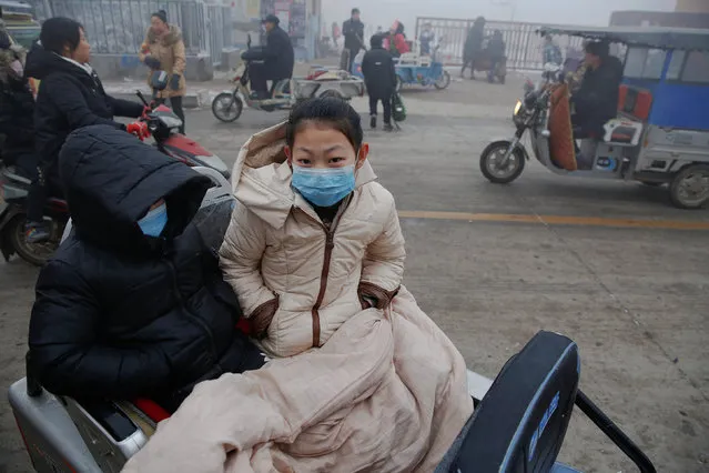 People wear face masks as heavy smog blankets Shenfang in Hebei province, on an very polluted day December 20, 2016. (Photo by Damir Sagolj/Reuters)