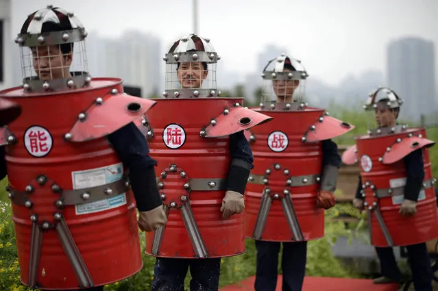In this Thursday, March 19, 2015 photo, workers in outfits made from scrap material parade through a farm on the rooftop of a door manufacturer in Chongqing municipality in southwest China. (Photo by AP Photo)