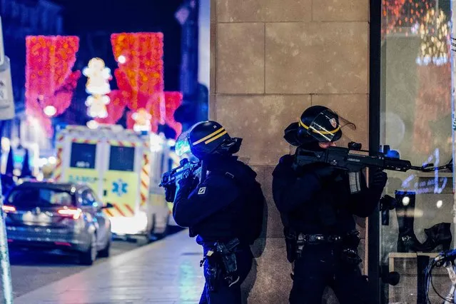 French police officers stand guard near the scene of a shooting on December 11, 2018 in Strasbourg, eastern France. A gunman killed at least two people and seriously injured another 11 near the famed Christmas market in the French city of Strasbourg before fleeing the scene, security officials said. Police launched a manhunt after the killer opened fire at around 7pm local time (1800 GMT), sending crowds of evening shoppers fleeing for safety. (Photo by Abdesslam Mirdass/AFP Photo)